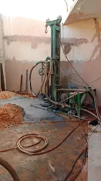 Perfuratriz em terreno urbano, junto a uma construção