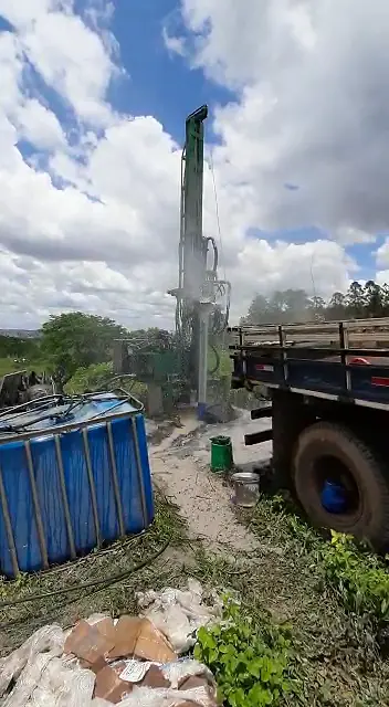 Perfuratriz e caminhão em área rural com vegetação